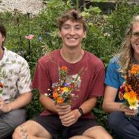 SAP interns pose with their floral arrangements in a seated manner.